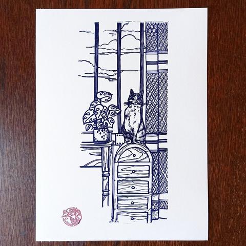Impression d'une gravure sur laquelle se trouve un chat assis sur un meuble devant une fenêtre.