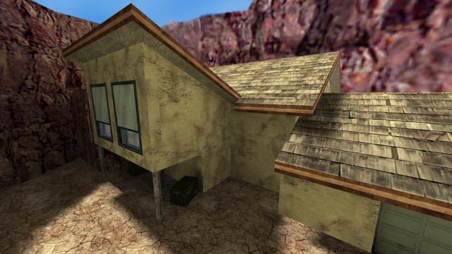 In this picture you can see a very large house. This is surrounded by rocks. The house has a large garage to the right. The house is two-storey. It has two large windows on the first floor. The blind of the windows is three-quarters closed. These windows belong to a room with a couch. Among these is the main entrance to the house. In addition, the house and the gerage have a grey pointed roof. However, the room with the couch only has a grey sloping roof. This is on the map cs_militia in the game Counter-Strike 1.6.