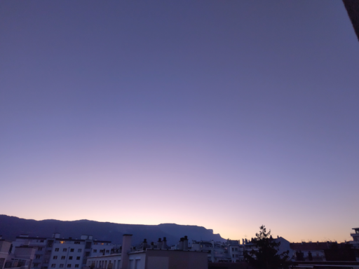 Grand ciel mauve rose orange en dégradé, au-dessus du Vercors. Immeubles au premier plan.