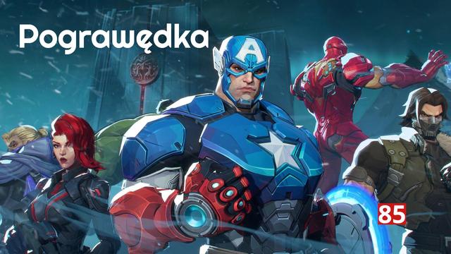 Grafika przedstawia baner z gry Marvel Rivals zatytułowany "Pograwędka 85". W centrum obrazu znajduje się Kapitan Ameryka w nowoczesnym, niebieskim pancerzu z charakterystyczną gwiazdą na piersi i literą "A" na hełmie. Po jego prawej stronie widoczny jest Iron Man w czerwono-złotej zbroi oraz Zimowy Żołnierz z maską na twarzy. Po lewej stronie Kapitana znajduje się Czarna Wdowa z czerwonymi włosami oraz inne postacie. Tło jest ciemnoniebieskie z padającym śniegiem, co tworzy dramatyczną atmosferę. W prawym dolnym rogu widnieje liczba "85"