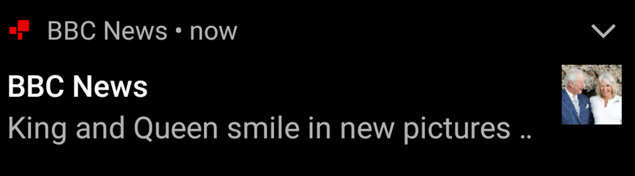 A screenshot of a BBC News notification that reads "King and Queen smile in new pictures ..", next to a thumbnail picture of the presumably chipper couple.