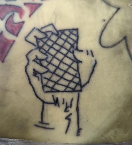 Black tattoo ink on fake skin

Comic style drawing

A hand Holding a card of something in that shape, that has a crosshatched pattern on it.