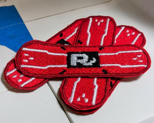 a small stack of red patches shaped like stylized bandages