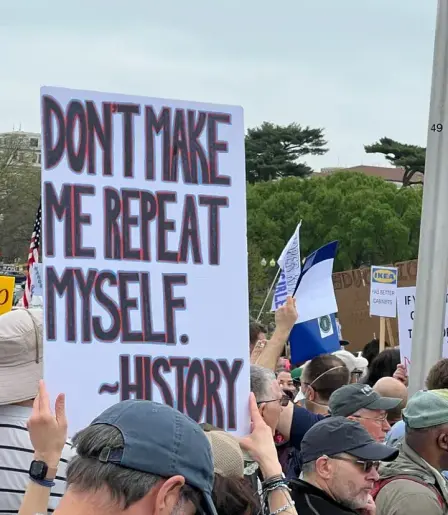A protest sign that says, "Don't make me repeat myself. ~History"