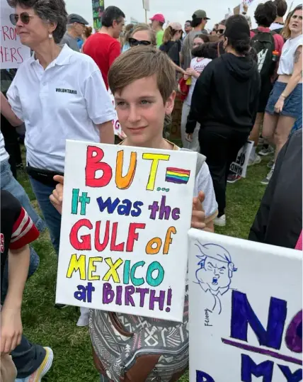 A smiling young protestor holds a sign that reads, "But... it was the Gulf of Mexico at birth."