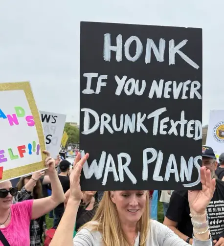 A protest sign that reads, "Honk if you never drunk texted war plans."
