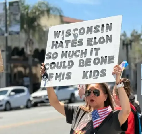 Protest sign that says, "Wisconsin hates Elon so much it could be one of his kids."