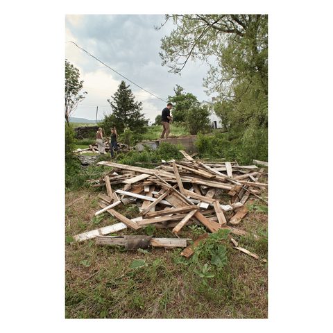 pile of broken lumber below a concrete slab in a clearing