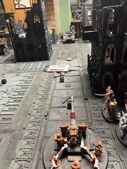 Warhammer 40K Battlefield 

Artillery Team and Lord Marshall lined up down a street facing a land raider.