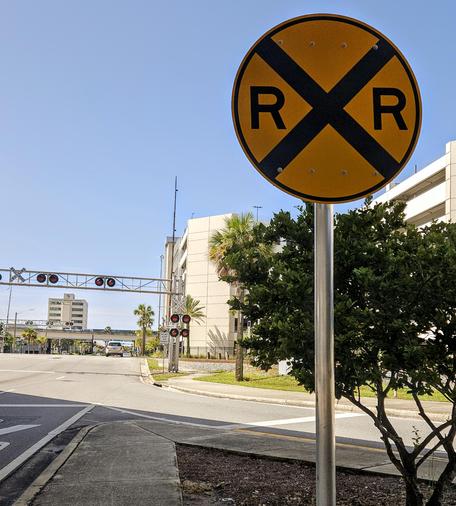 View as approaching a set of railroad tracks with a big yellow caution sign, alerting to the crossing (R x R)