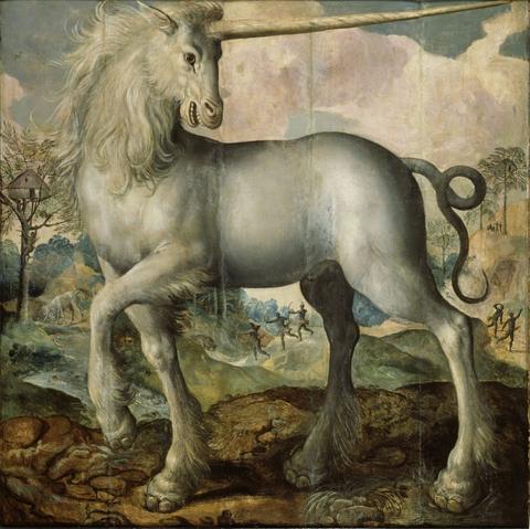 White unicorn with shaggy white mane and hooves and long spiralling horn. It is smiling.