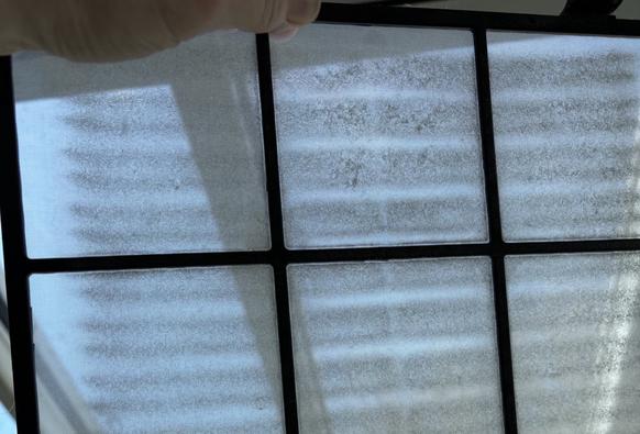 Nahaufnahme: Grobfilter gegen das Licht gehalten, hier Filter mit Staubpartikeln.