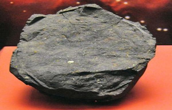 a dark grey chunk of rock on a table