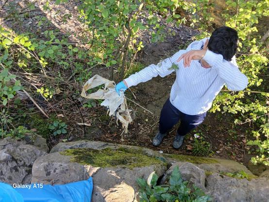 Gazte bat errekondoko zaborra batzen.