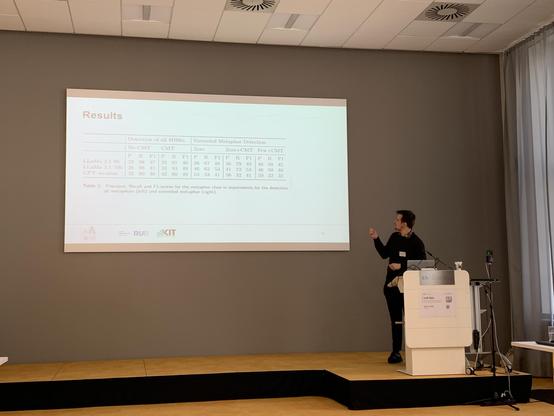 Sebastian Reimann pointing at a screen, which shows results from LLMs