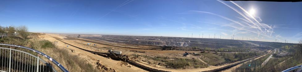 Panorama vom Tagebauloch Garzweiler mit ein paar Windkraftanlagen im Hintergrund