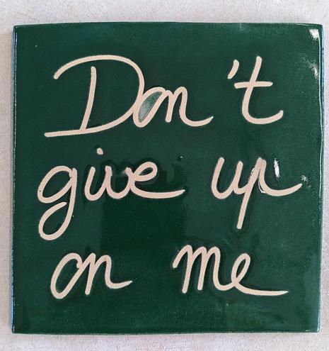 Green square ceramic tile. Handwritten in white "Don't give up on me"