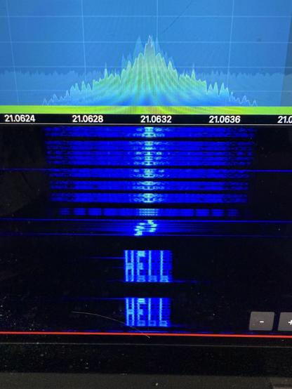 Buntest Spektrum und Wasserfalldiagramm, von einem Bildschirm abfotografiert. Im Wasserfall stehen 2 x das Wort  "HELL" .