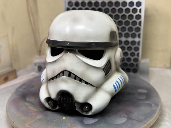 A 3d printed stormtrooper helmet from Star Wars looking dirty and used. The image shows it from the front just slightly off the center.