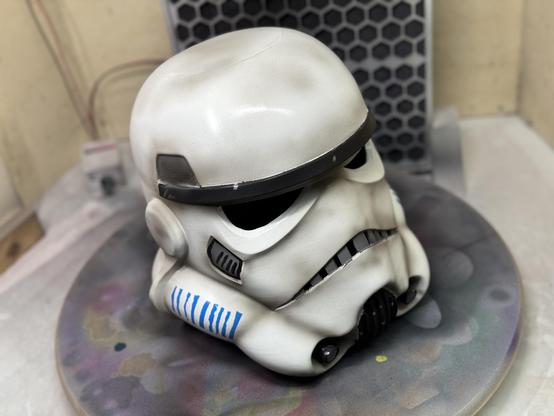 A 3d printed stormtrooper helmet from Star Wars looking dirty and used. The image shows it from its top right side.