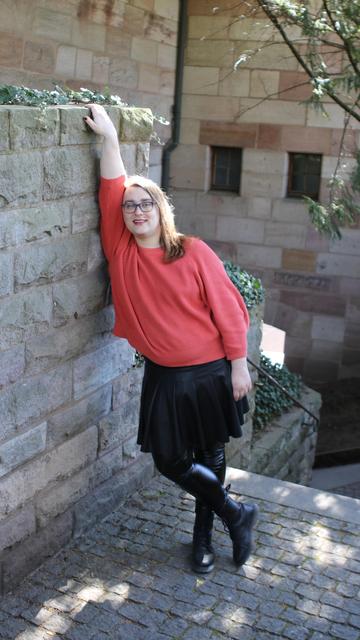 Me leaning against a wall, standing with my legs crossed and grabbing the ledge above me