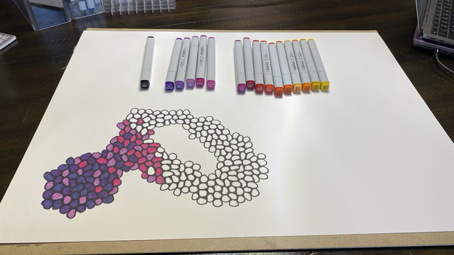 Wide shot of brand new drawing starting at the lower left corner with a covering of purplish blobs fading into magenta blobs, and with the set of markers I plan to use for it