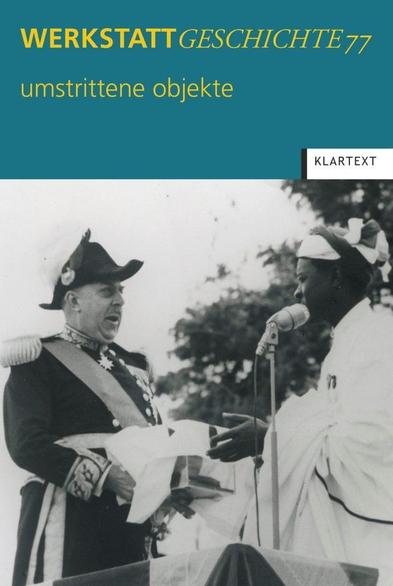 Frontcover WerkstattGeschichte 77/2018 mit Ausschnitt eines Schwarz-Weiß-Fotos von der offiziellen Übergabe des Schädels von Chief Mkwawa (verborgen in einem tuchbedeckten Kasten) durch Gouverneur Sir Edward Twining (in repräsentativer, dunkler Uniform mit Epauletten, Schärpe und Orden auf der Brust) an Mkwawas Enkel, Chief Adam Sapi (in traditionellem, weiten, weißen Gewand), Tansania 1953. Mkwawa starb 1898 am Ende des Kolonialkriegs zwischen dem Deutschen Reich und den Hehe. Sein Kopf wurde von einem deutschen Soldaten abgeschlagen und der Schädel wohl nach Deutschland verbracht. Wir danken dem Staatsarchiv Bremen für die freundliche Überlassung des Bildes.