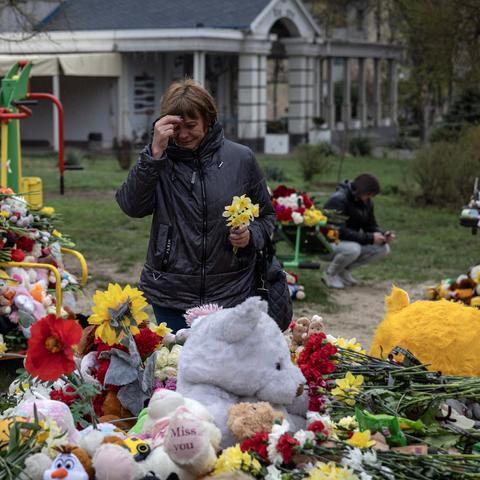 A woman prays at a makeshift memorial in Kryvyi Rih, Ukraine, where a Russian Strike on Friday killed 19 people, including nine children.