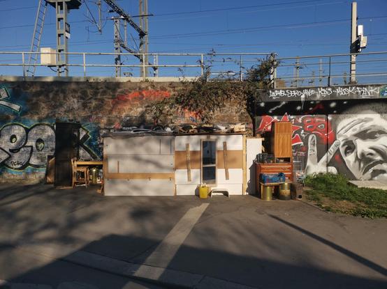 A small home made of reclaimed parts, along train tracks.