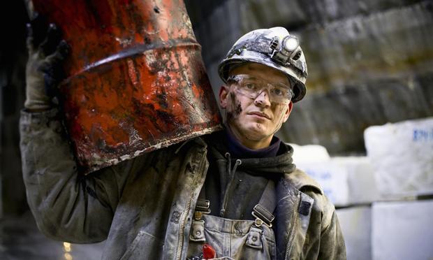 Imagen de un hombre cargando con un barril de petróleo. (Tyler Stableford via Getty Images)