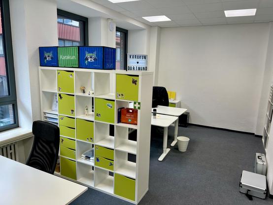 Modernes Büro mit buntem Regal, Arbeitsplätzen und Karakun-Branding in der Niederlassung Dortmund.