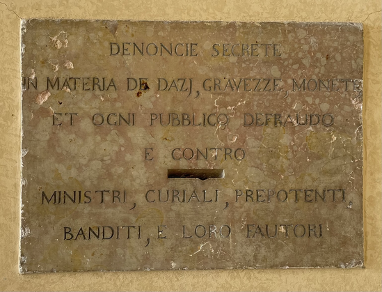 Lastra in pietra antica posta nel Castello di Udine che invita a imbucare proteste per dazi, ministri e persone pubbliche prepotenti.