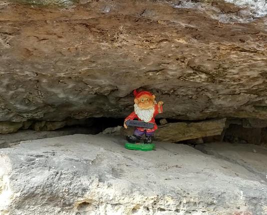 Kleine Zwerg  unter einem Felsen mit einem Schild (Hochwasser(z)we(r)g