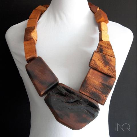 el mismo collar de madera de la foto anterior visto de frente sobre fondo negro