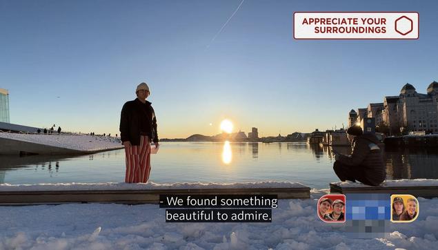 A photo of Ben and Adam from Jet Lag the game sat on the waterside at the Oslo opera house before a sunset and clear blue skies over a still water. the caption reads "we found something beautiful to admire"