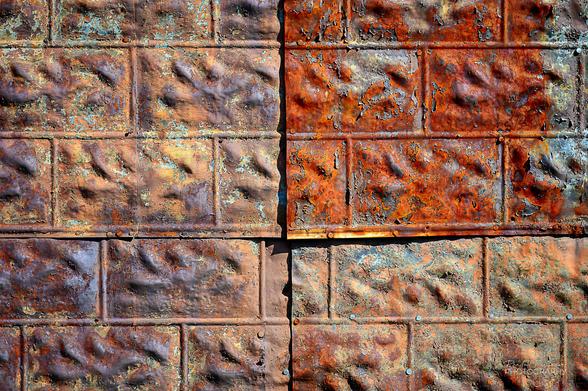 Four pieces of overlapping metal siding stamped to look like stone.
