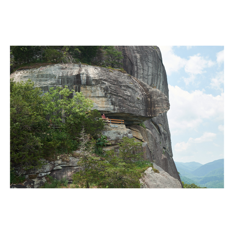 small observation platform nestled under rock ledge protruding from sheer cliff