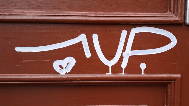 Ausschnitt eines roten Türrahmens mit Zierleisten. Mit weiß wurde "1 Up" draufgeschrieben. Unter der 1 ist ein kleines, weißes Herz.