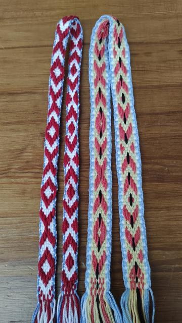 Two woven narrow bands, showing front and back of each band.
The mostly red and white band has mistakes visible on the back.
The blue, yellow, coral and black band has fewer mistakes!