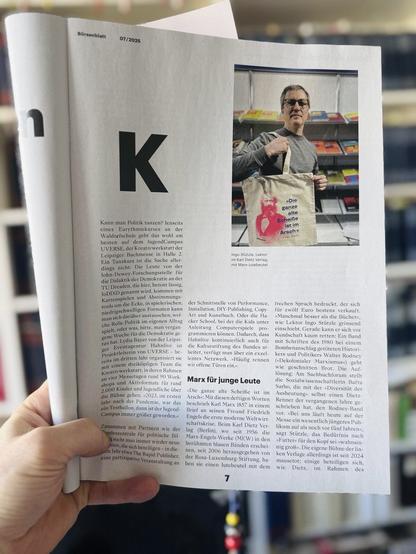 Aufmacherseite im Magazin des Börsenblatts, der Publikation des Börsenvereins des Deutschen Buchhandels: Abgebildet ist Ingo Stützle mit unserer Marx Tote Bag »Die ganze alte Scheiße ist im Arsch« am Messestand von Dietz Berlin und der Rosa Luxemburg-Stiftung auf der Leipziger Buchmesse.