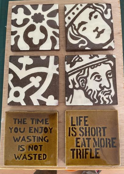 Photo of six 4 inch handmade tiles decorated with text and medieval designs using the sgraffito technique