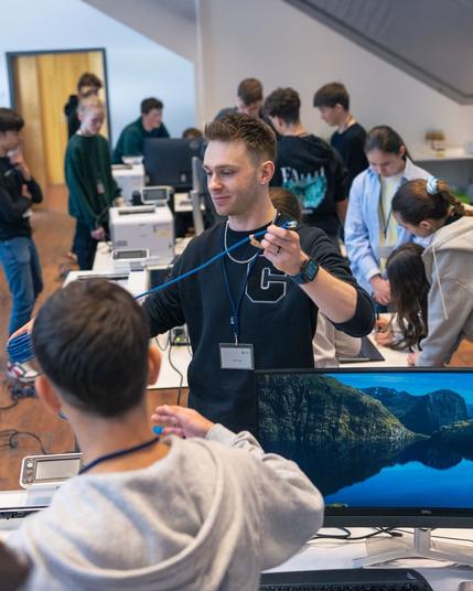 Schüler:innen bauen einen Desktop-Arbeitsplatz zusammen mit Haufe Group Kolleg:innen auf.