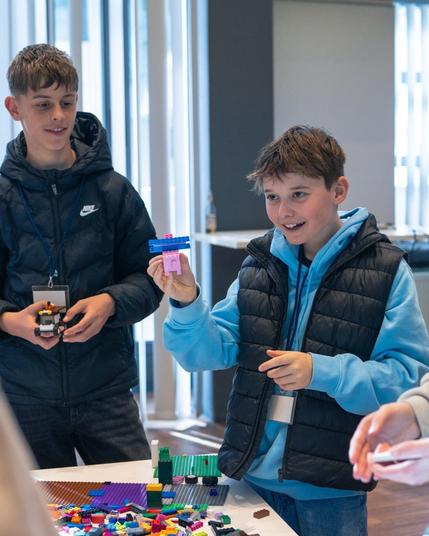 Ein Schüler zeigt sein mit Lego gebautes Werk zur Arbeitswelt.