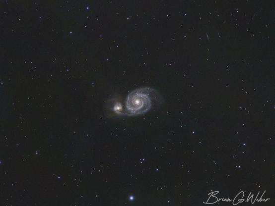 Subject: Whirlpool Galaxy, M51. The galaxy sits in the center of the frame with a yellowish blob on the left side (actually a separate galaxy) and the blue spiral of the galaxy to its right.