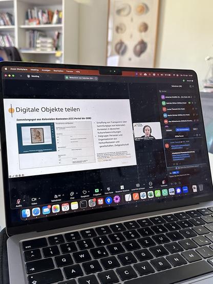 Foto eines MacBooks auf dem gerade Zoom-Läuft. Zu sehen ist neben der vortragenden Person (Gabriele Zöllner) eine Folie mit dem Titel „Digitale Objekte teilen“ und ein Screenshot des CCC-Portals der DDB.