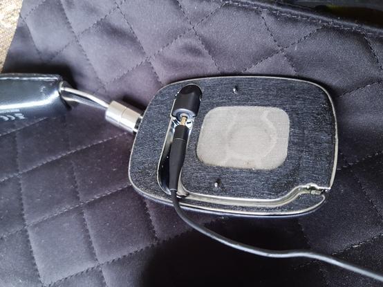 Photo of the inside ear pad base of my headphones with the port to click in the cord that also clicks in to the headphone jack on my phone.