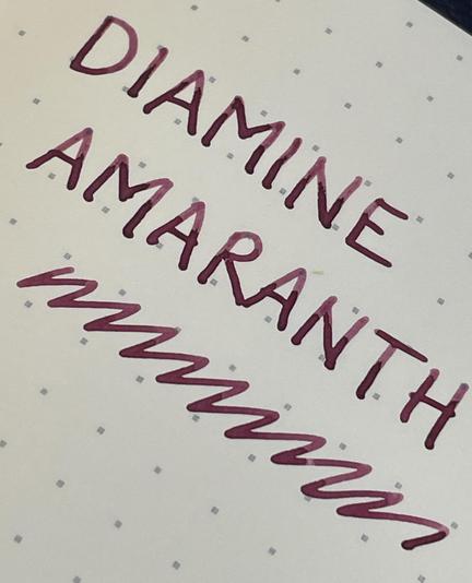 The words "DIAMINE AMARANTH" written in a bold, pinkish-red ink on a dotted notebook page.