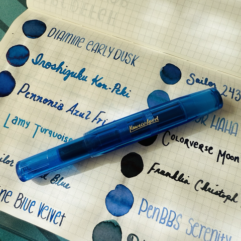 Small blue pocket fountain pen laid on top of a notebook