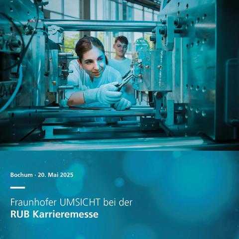 Eine Wissenschaftlerin arbeitet an einer Maschinenkomponente in einem modernen, hellen Arbeitsumfeld. Im Hintergrund ist ein weiterer Forscher zu sehen.
