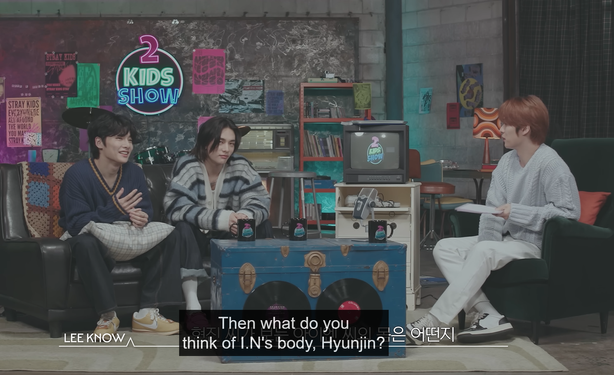Lee Know interviewing I.N and Hyunjin on the 2 Kids Room show. Lee Know says, "Then what do you think of I.N's body, Hyunjin?"